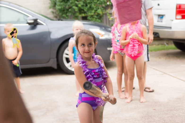 girl with purple swimsuit throwing ball at girl in bikini