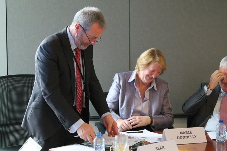 two men and a woman are smiling as they work together