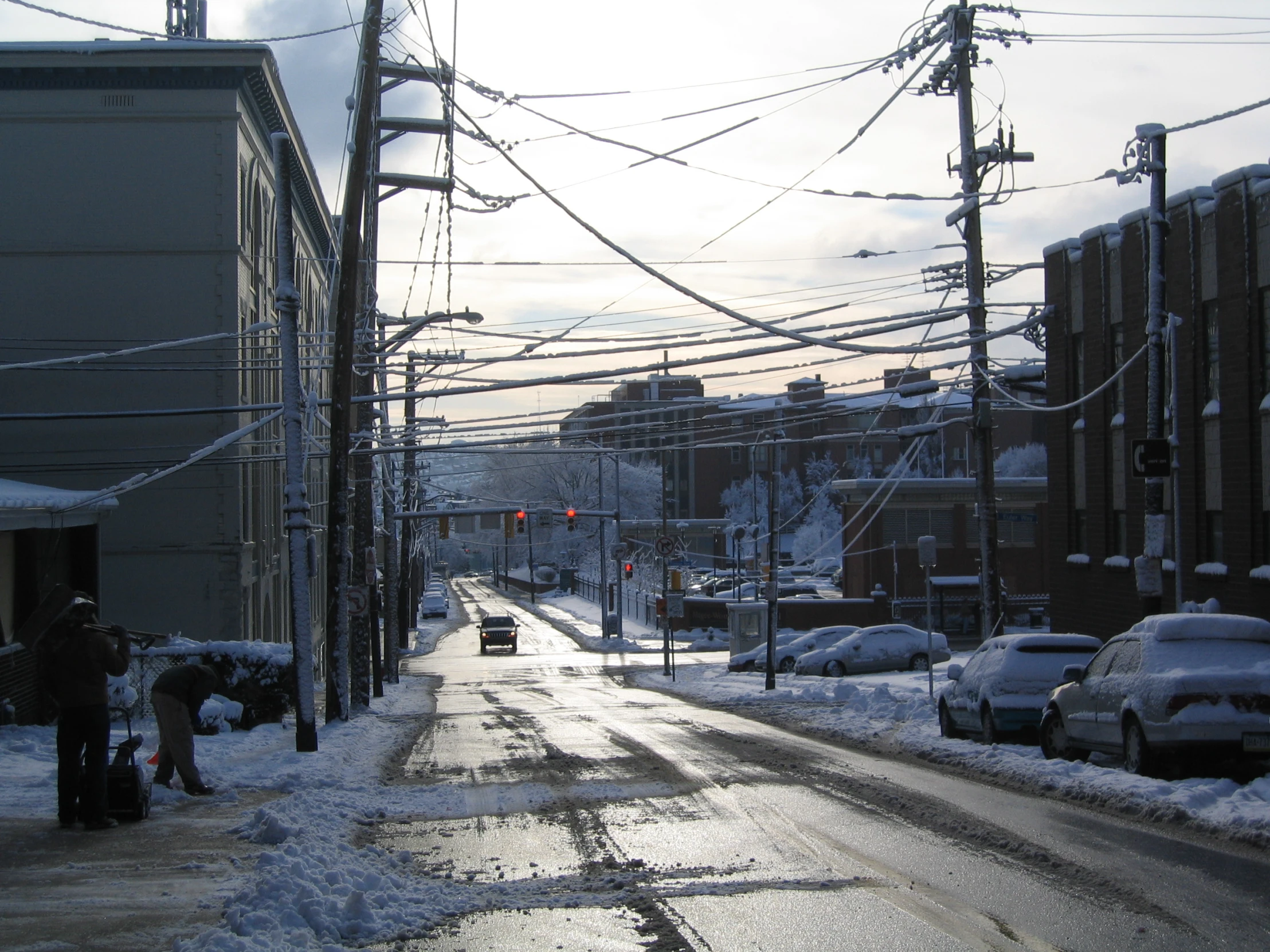 a person and a child standing on the side of a snow covered road