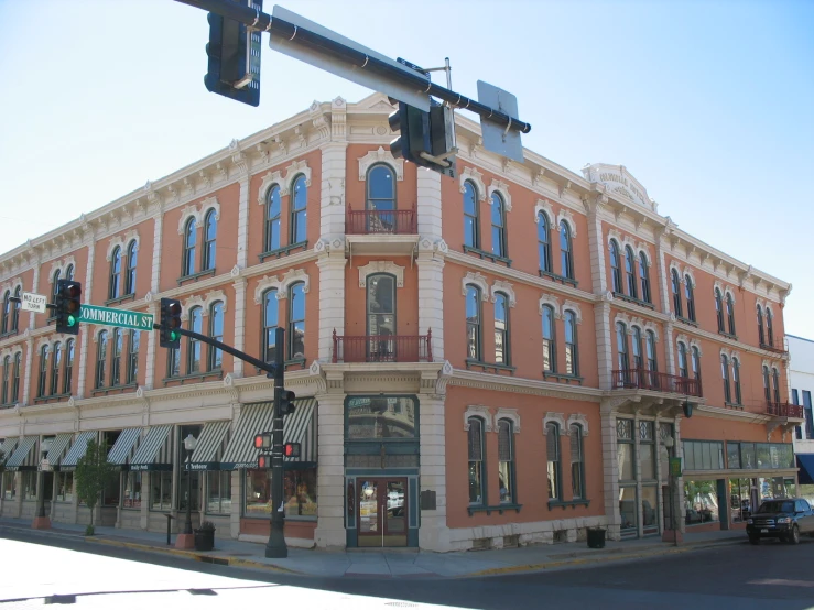 an old red building is across the street from a traffic light