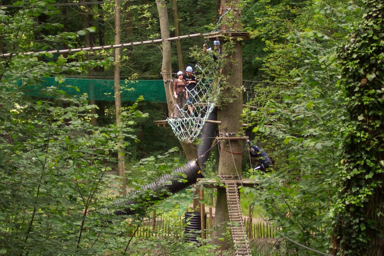 two people standing on an obstacle course in the woods