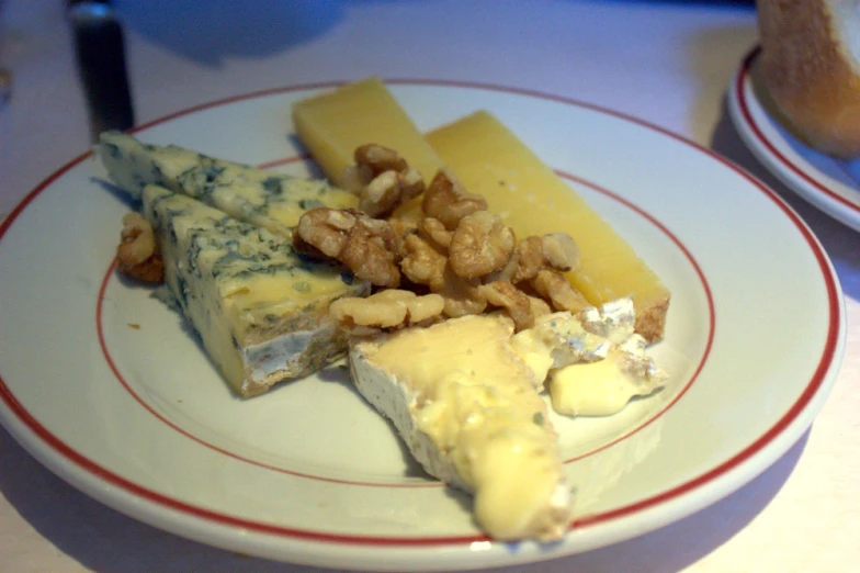 a cheese plate with cheese, nuts, and parmesan cheese