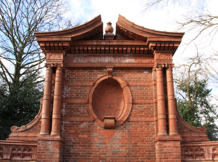 an orange brick tower with a roof that has a small window above it