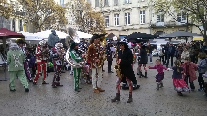 an outside town square where people are dressed in costumes