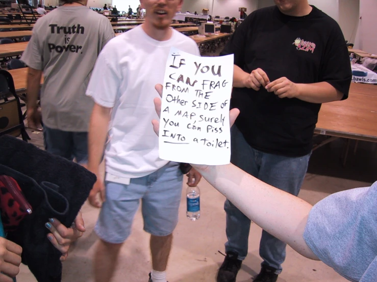 several men hold a sign with words on it