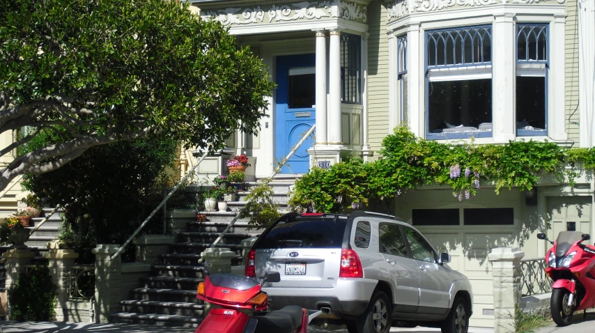 a car parked on the side of the street near a motorcycle