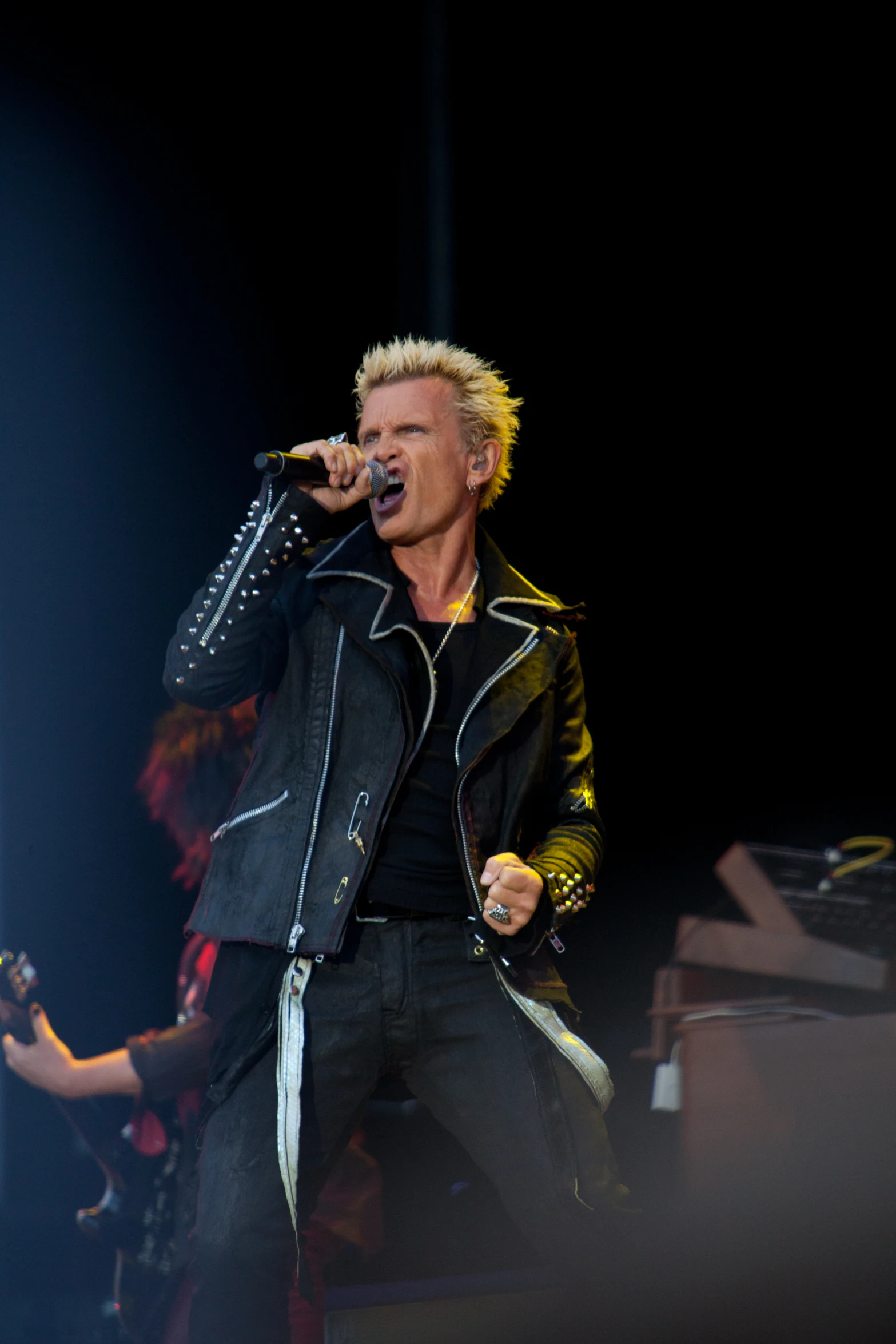 blond rocker holding microphone up to his face on stage