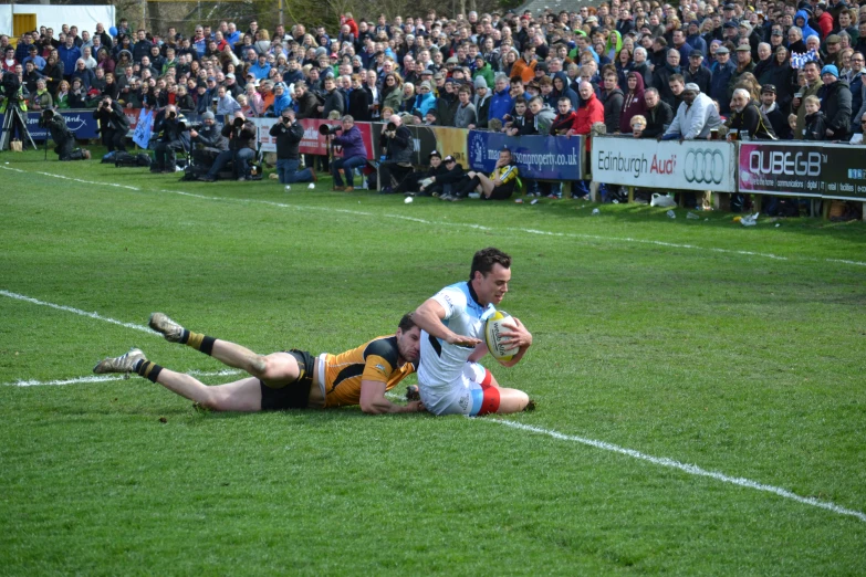 man diving for the ball, running and getting tackled by another man