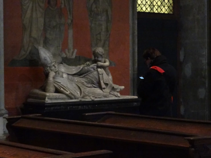 a woman is standing by an enormous statue