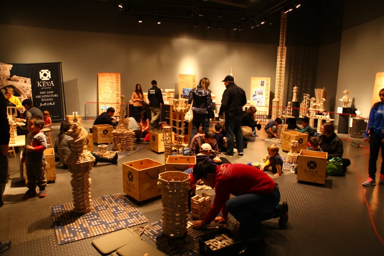 a group of people at an exhibit with many wood structures