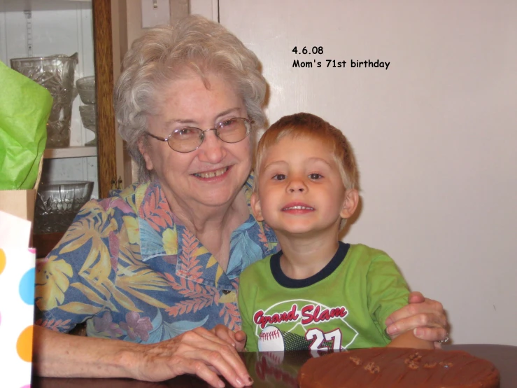 the elderly woman smiles next to a child at a table with food on it