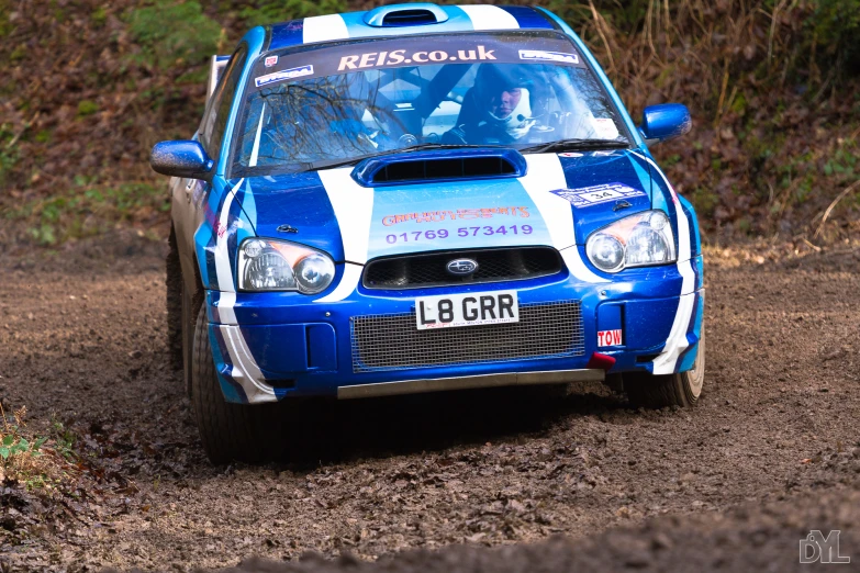 a rally car driving down the dirt road