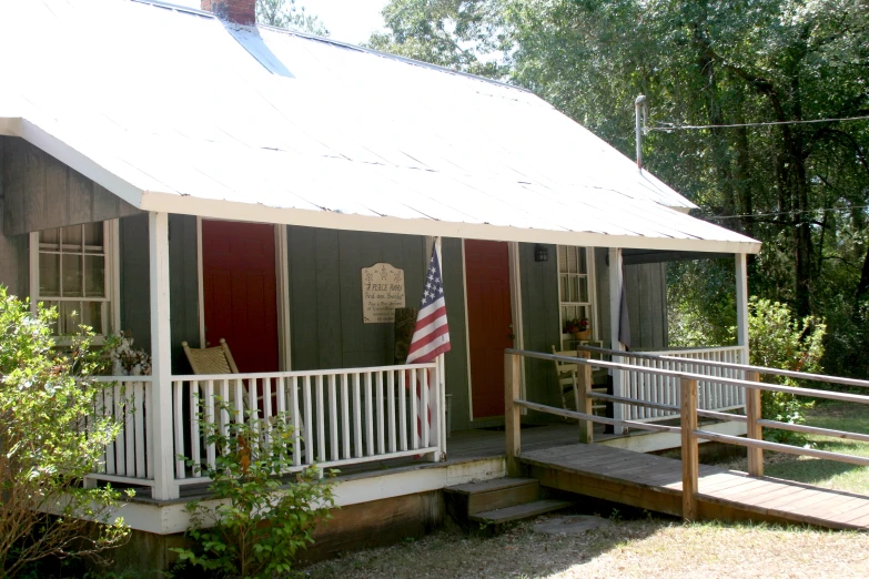 a flag on a porch of a small cabin