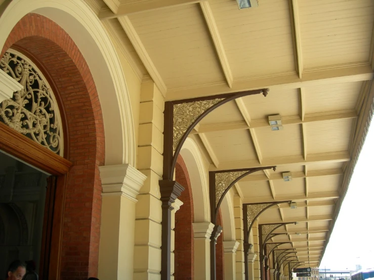 a walkway between two buildings with people walking on the side