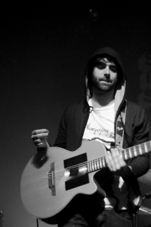 a man holding a guitar while standing on stage