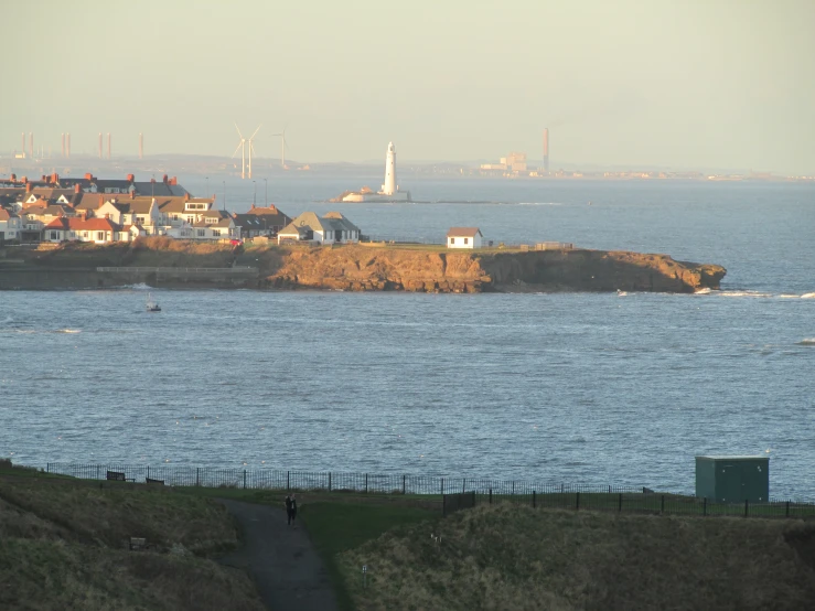 a boat is in the water at a lighthouse