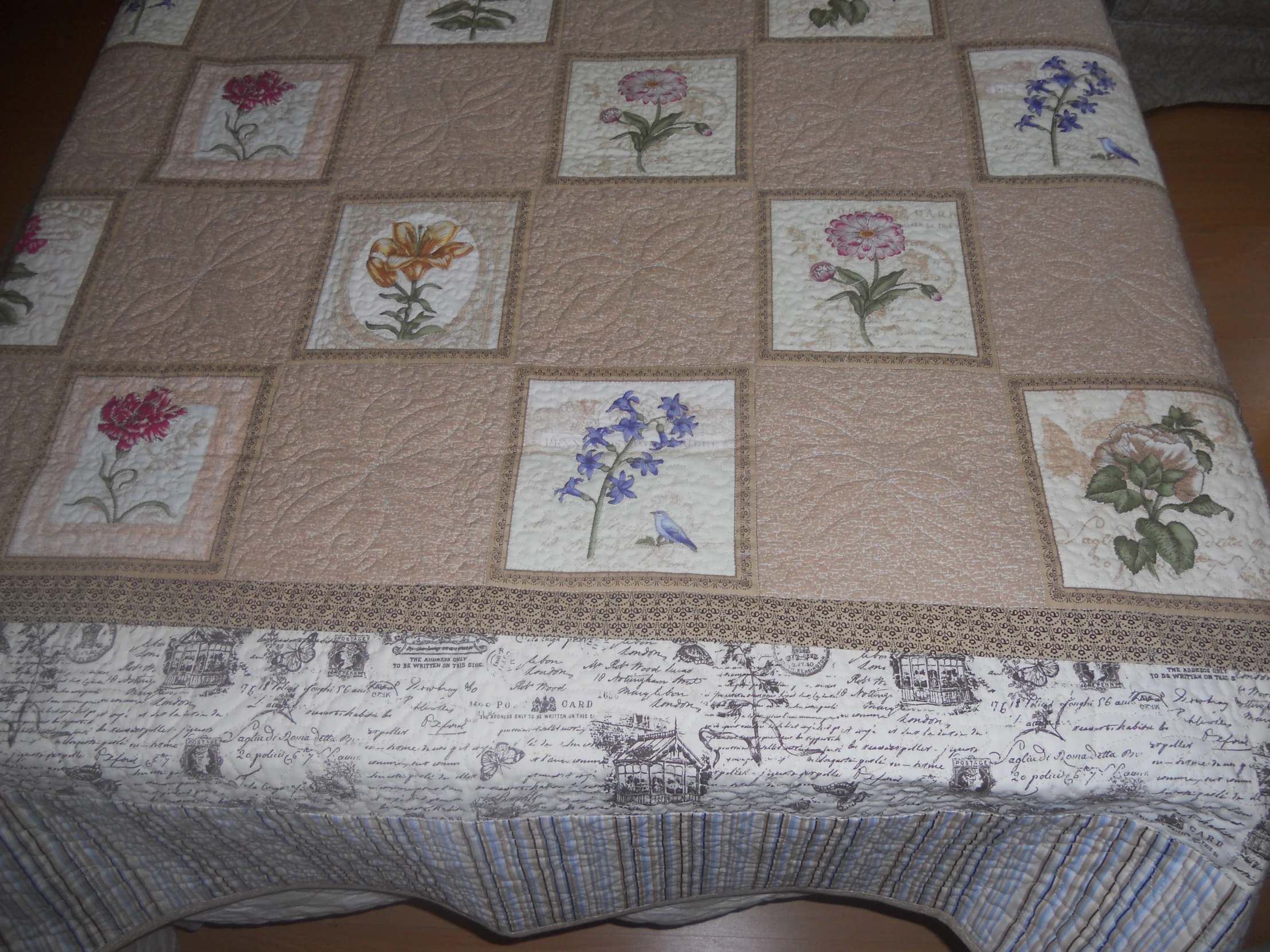 a blanket with several squares and flowers on it