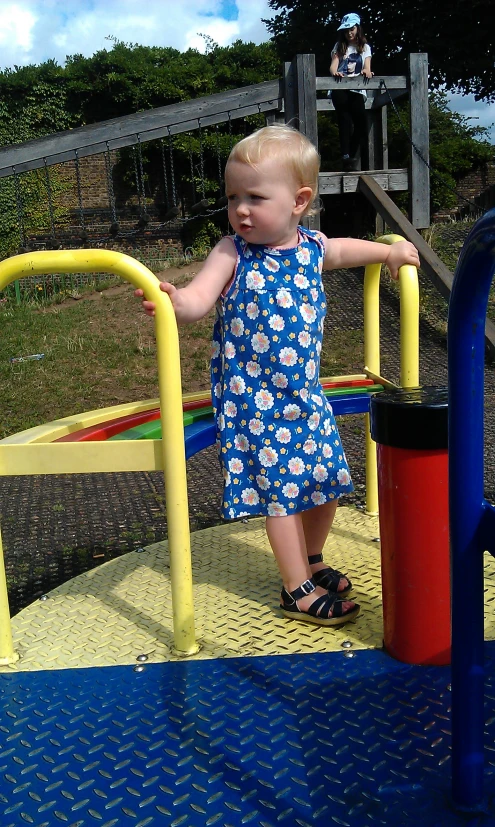 a child in the playground on a play set