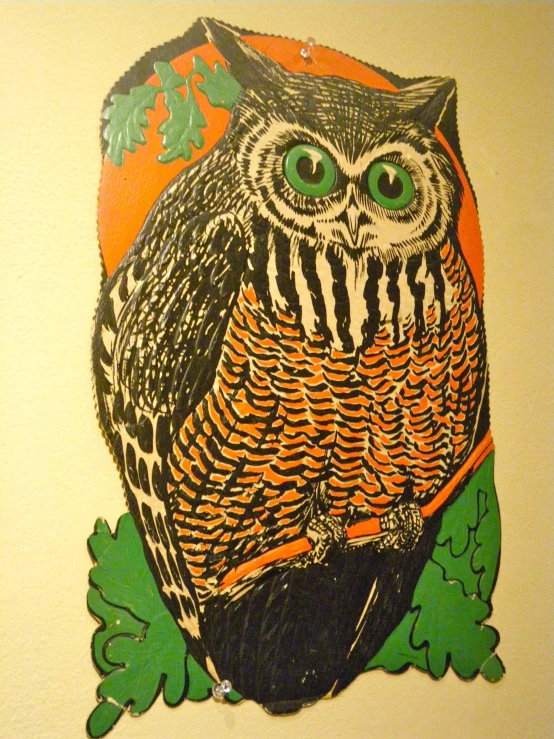 an owl with big green eyes on a white wall