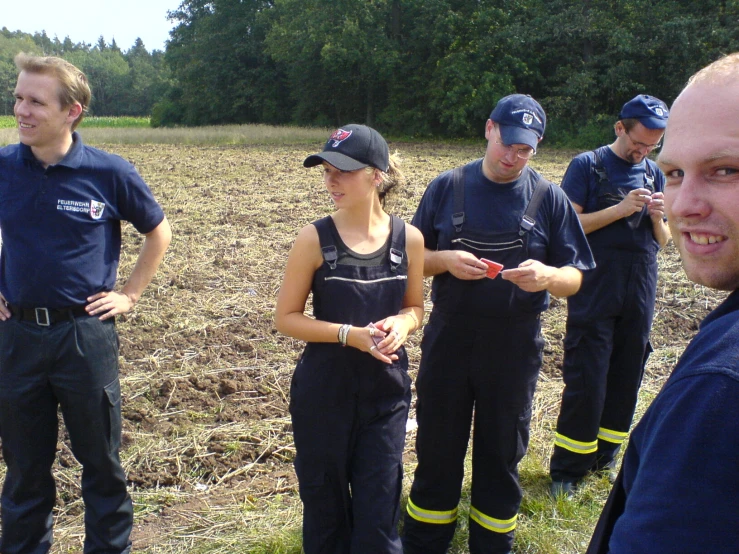 four firemen standing by one another on a field