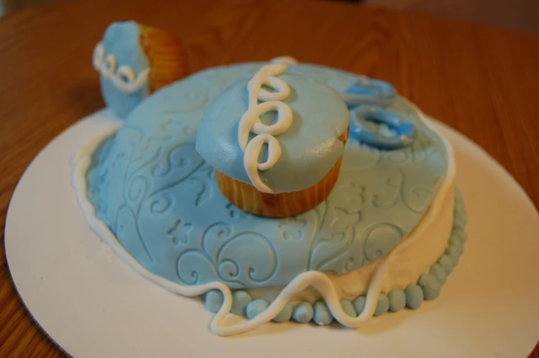 two cupcakes made from frosting sitting on top of a cake