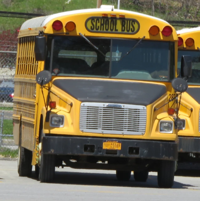 the school busses are parked along the curb