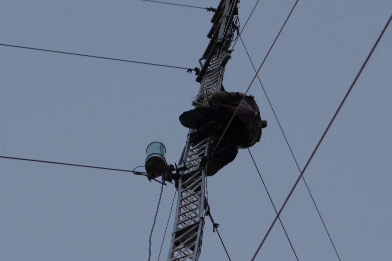 two people stand on the top of power lines