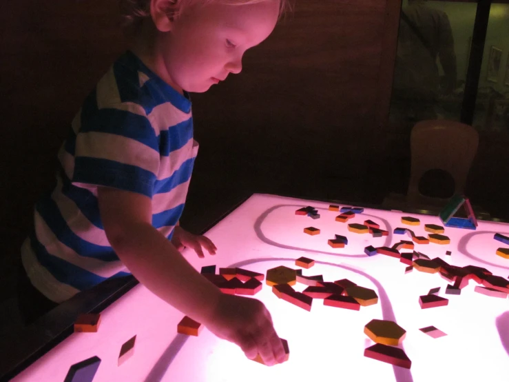 the baby is playing with blocks in the dark