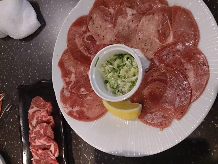 meats are shown on a white plate with a small bowl of coleslaw