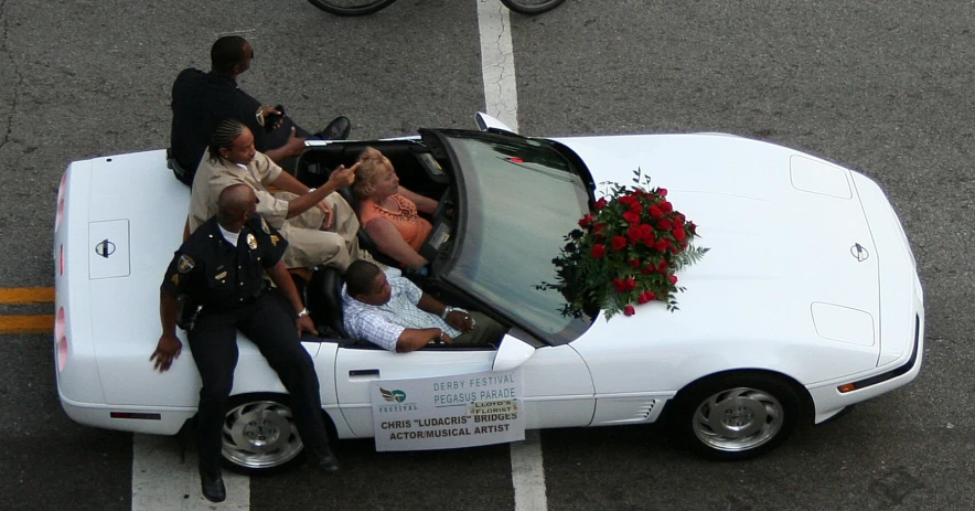 a group of people riding in the back of a white car