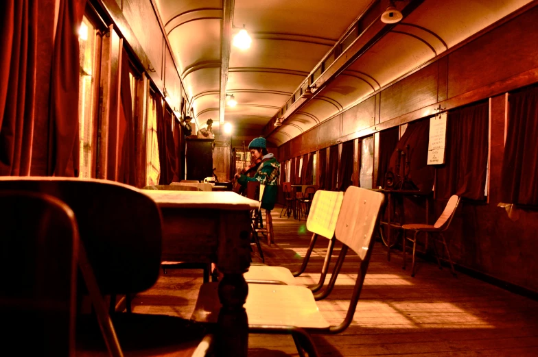 a man standing in a dark train with many chairs