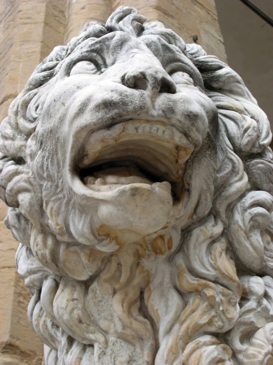 an ornate stone head sits in front of a column