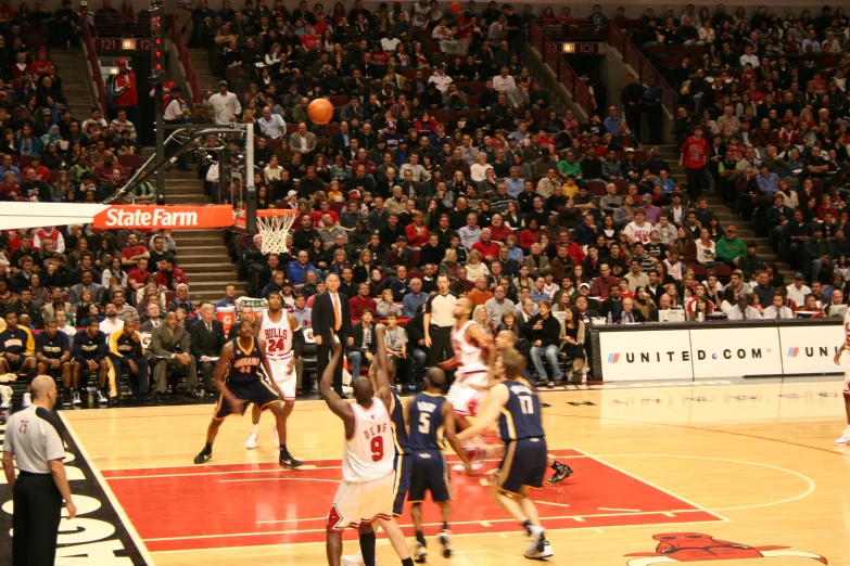 several people playing basketball while spectators watch from the sidelines