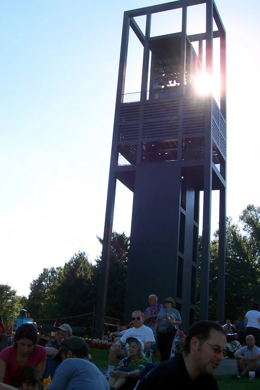 a very tall clock tower sitting on the side of a grass field