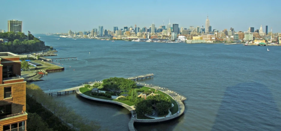 a scenic view of an island with water and a large city in the background