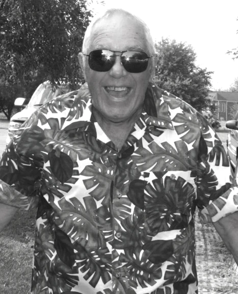 an older man wearing sunglasses standing next to a street