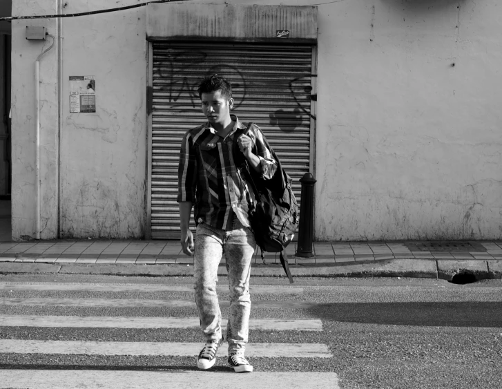 a man walking down the street carrying a backpack