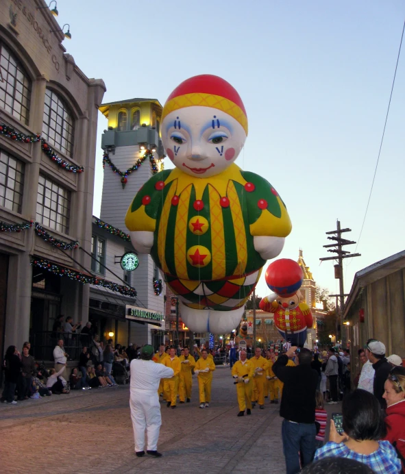 a group of people walking on the street with a balloon