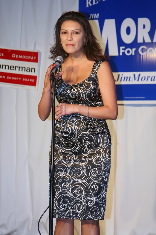 a woman in a short dress standing with a microphone