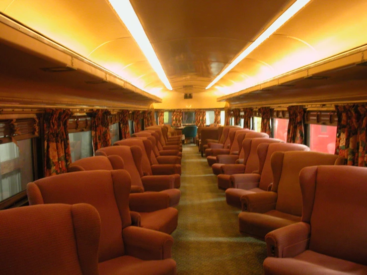 rows of empty chairs lined up inside an indoor subway car