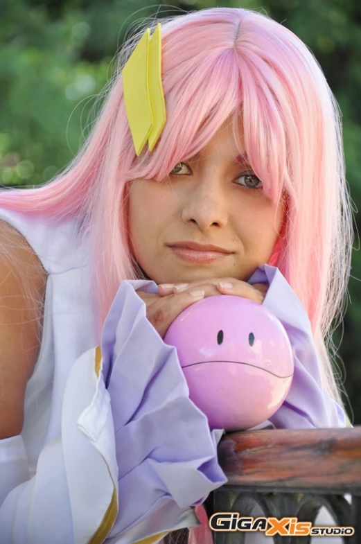 a woman with pink hair has pink makeup and wears a pig pig mask