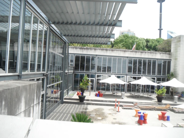 a glass enclosed patio outside a building with tables and chairs