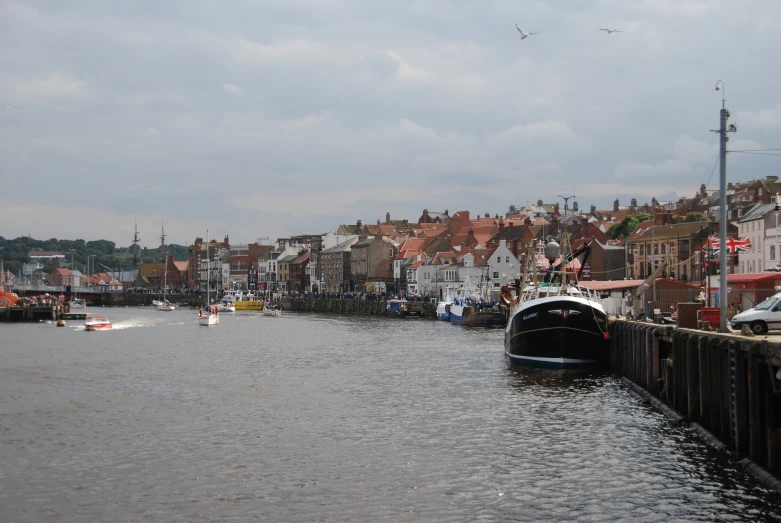 the water is reflecting houses and boats along with other houses