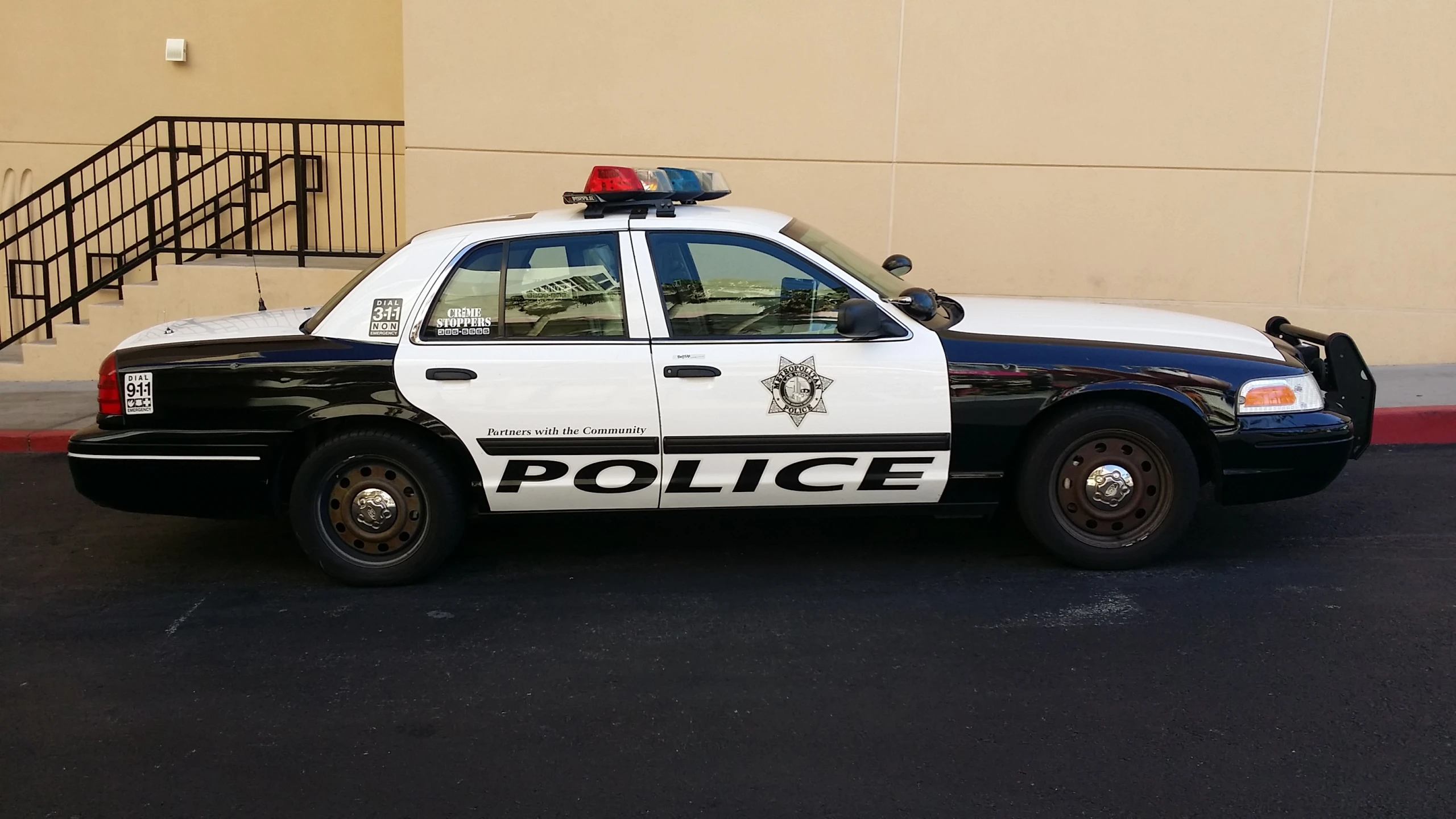 the police car is parked in front of a building