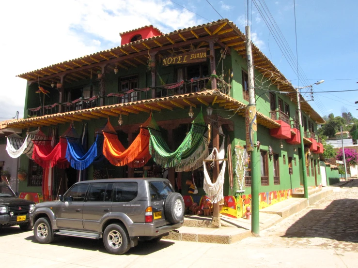 a green building is adorned with some colorful fabric