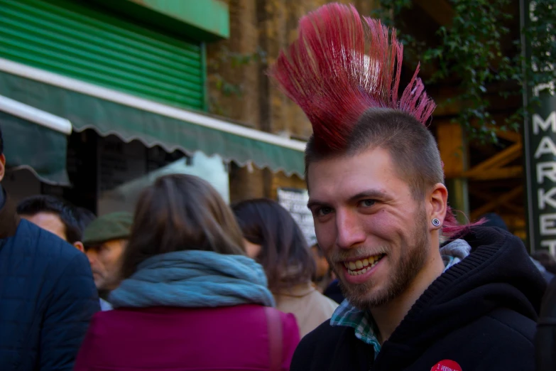 a man in a crowded street wearing a weird head piece