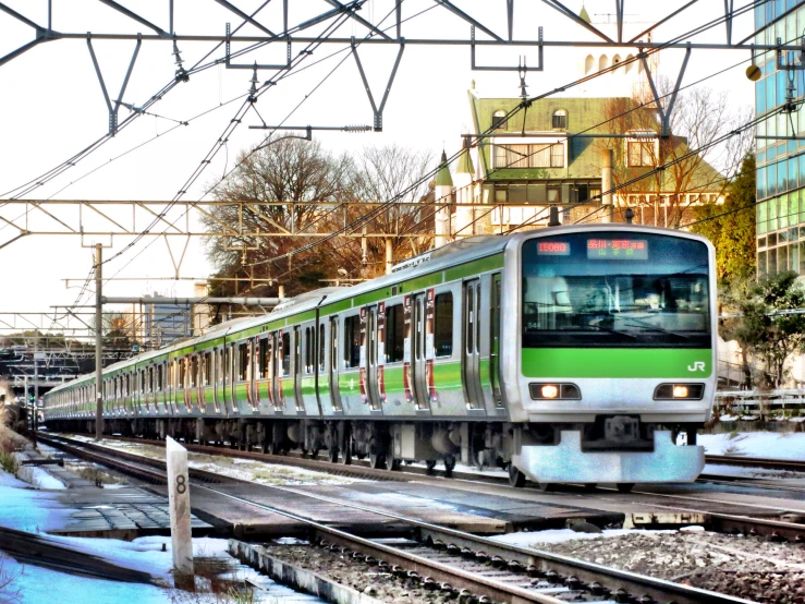 an electric passenger train on the tracks near buildings