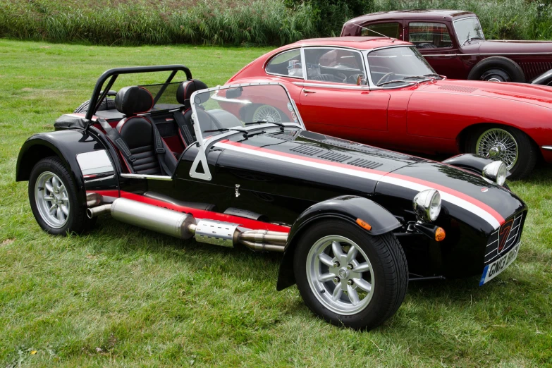 several different old cars sitting in the grass