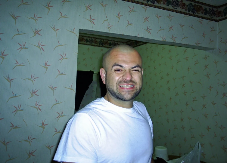 a man with bald head standing in a room