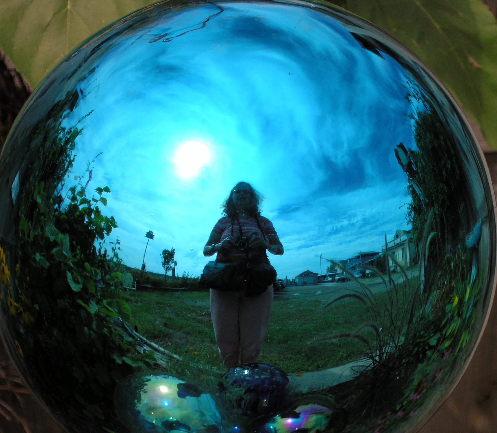 woman standing in the middle of a field reflecting her reflection in the mirror